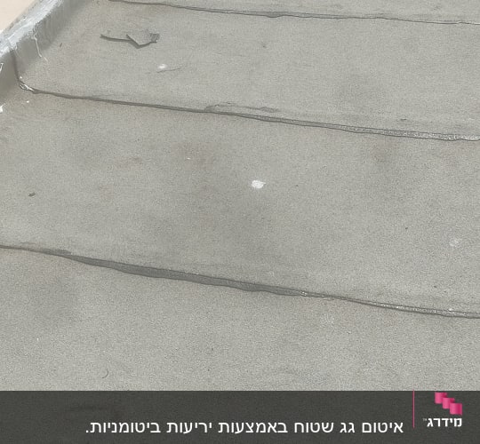 גג אטום עם שכבת איטום אפורה וצינורות אטומים